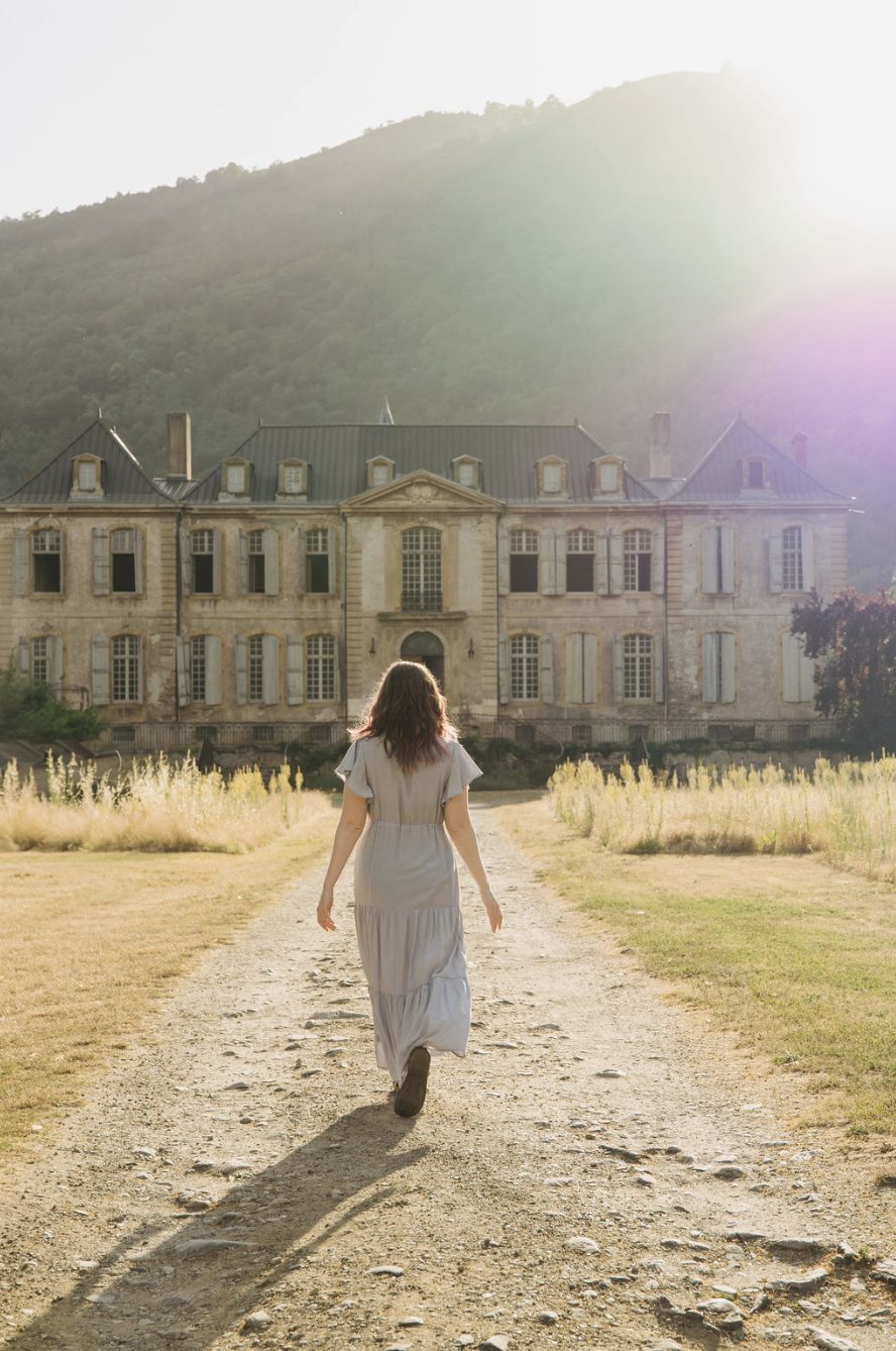 A guest walking up to the château through the meadow