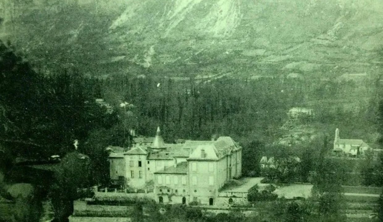 The château in its valley below the mountain, on an early postcard